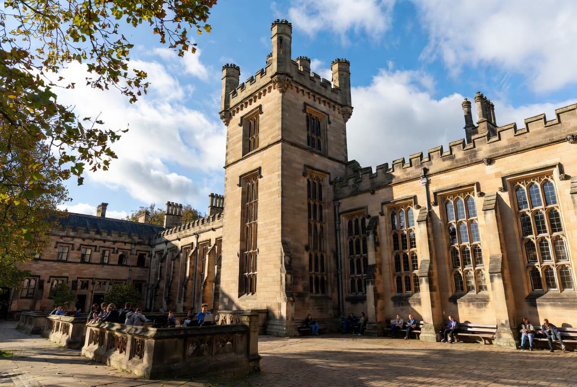 Sandstone courtyard with students and a central tower